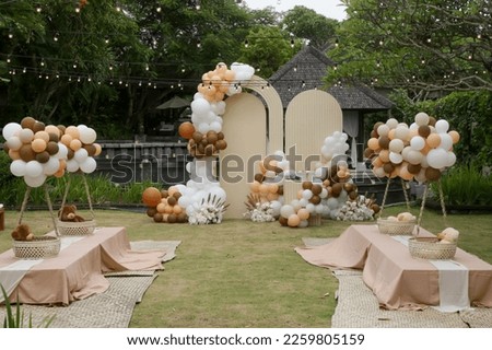 Creative gender neutral baby shower or birthday decoration in the garden. Bohemian style outdoor event set up with balloons.  Royalty-Free Stock Photo #2259805159
