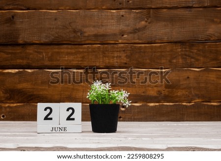 June calendar with number  22. Planner copy space on a wooden brown background. March number icon. Place for text background calendar