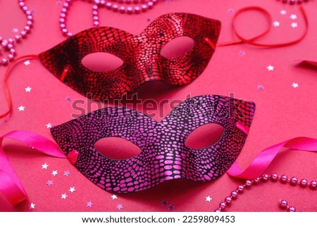 Carnival masks with stars and beads on pink background, closeup