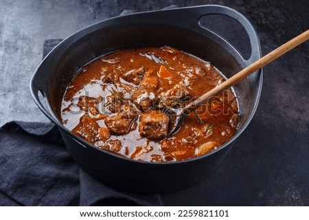 Traditional Hungarian braised venison goulash with vegetable and herbs in spicy sauce served in a design stew pot  Royalty-Free Stock Photo #2259821101