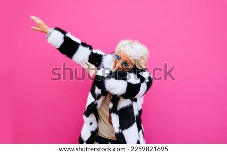 Happy grandmother posing on colored backgrounds. Woman having fun and celebrating