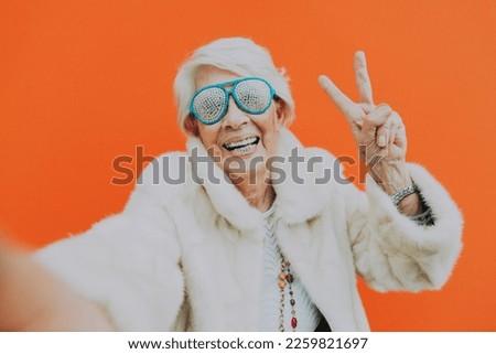 Funny grandmother dancing on colored background
