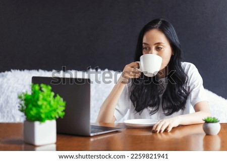 Profile side photo of smart brunette girl ceo expert sit desk work remote laptop texting typing report hold beverage mug in house indoors on black background
