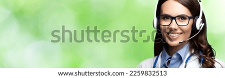 Medic Help Call Center. Face portrait image of smiling doctor in headset. Woman in eye wear glasses spectacles blurred outdoors background Video zoom conference health care advise answering ad concept