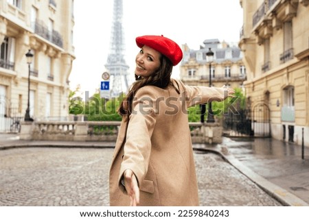 Beautiful young woman visiting paris and the eiffel tower. Parisian girl with red hat and fashionable clothes having fun in the city center and landmarks area Royalty-Free Stock Photo #2259840243