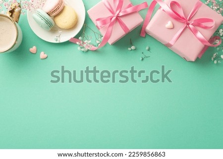 Mother's Day concept. Top view photo of pink gift boxes with ribbon bows dish with macaroons cup of hot drinking small hearts and gypsophila flowers on isolated turquoise background with copyspace