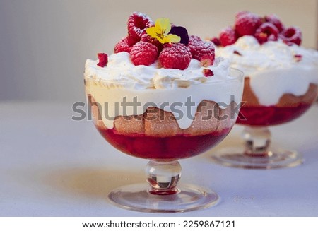 Raspberry trifle with fruit jelly, custard and cream Royalty-Free Stock Photo #2259867121