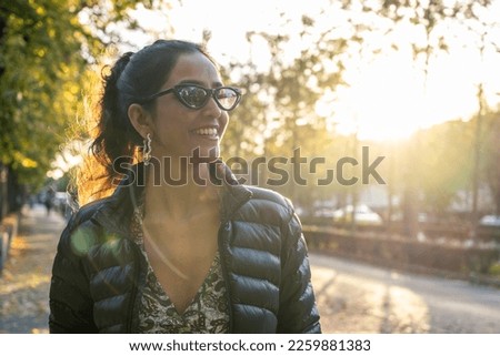 Female tourist enjoy walking through the streets of an European city at sunset with backlight