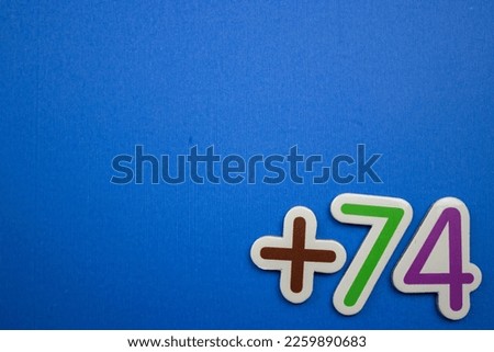The colorful text +74 is placed at the bottom right of the blue background.