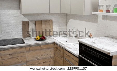 A plate with lemons is standing on the countertop. Bright white kitchen. Kitchen set. White kitchen set.
