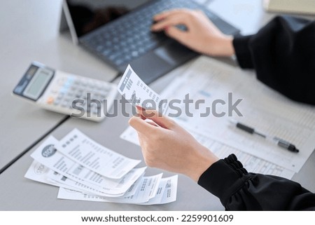 Asian woman entering expenses in accounting software Royalty-Free Stock Photo #2259901609