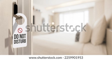 Hotel room door with please do not disturb sign. Entrance door of hotel room with sign reasons, to get out of bed. Prohibition sign. Royalty-Free Stock Photo #2259901953