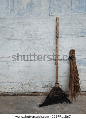 sweep the floor and broom stick with the back wall of the house