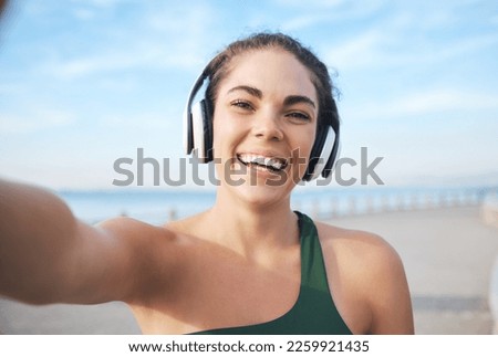 Selfie, fitness and woman headphones for outdoor training, running or exercise on video call for influencer update. Music, portrait and profile picture of sports person at beach workout or cardio