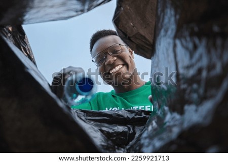 Recycle, smile and black man with view in bag, sustainability and cleaning plastic pollution, earth day and help in community. Saving the environment, charity and people putting trash in garbage bin.
