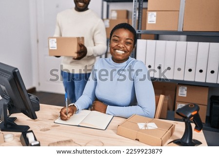 Man and woman ecommerce business workers writing on notebook at office