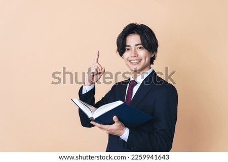 Young Asian man holding a book