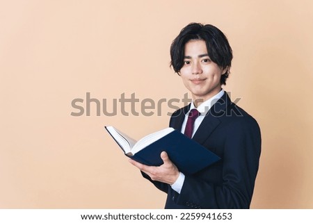Young Asian man reading a book