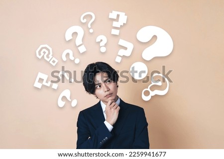 Young Asian businessman having questions. Royalty-Free Stock Photo #2259941677