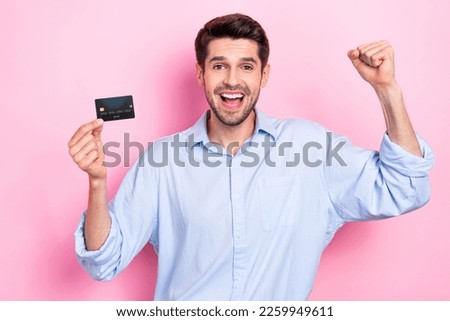 Photo of overjoyed man millionaire raise hand fist showing golden card unlimited credit isolated on pink color background