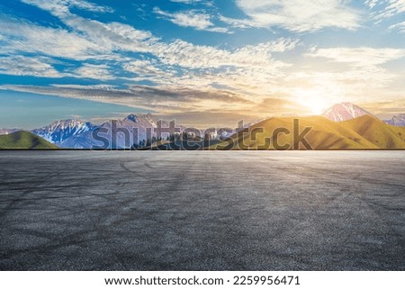 Asphalt road with green mountain nature landscape in Xinjiang at sunset, China.