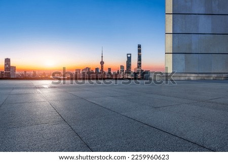 Empty square floor and city skyline with modern buildings at sunrise in Shanghai, China.