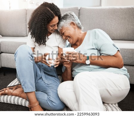 Relax, laughing and senior mother and daughter with coffee cup for home conversation, talking and bonding together. Black family, people or woman with elderly mom love, tea and living room carpet Royalty-Free Stock Photo #2259963093
