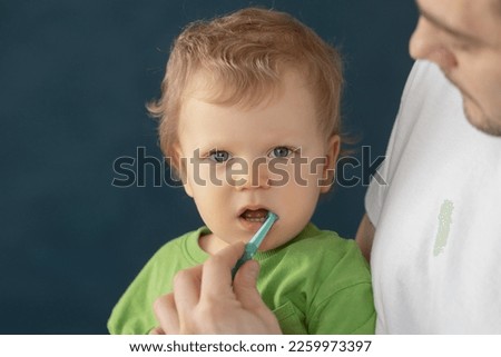 Cute baby 2 years old brushes his teeth with a toothbrush. The concept of oral hygiene and healthy teeth from infancy. Royalty-Free Stock Photo #2259973397