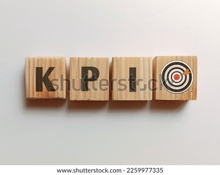 View of wooden square with a KPI or Key Performance Indicator and business goals icon on white background.  Royalty-Free Stock Photo #2259977335