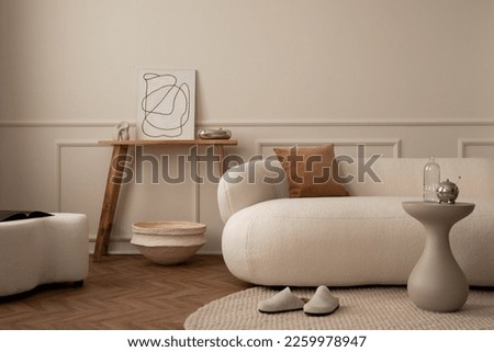 Warm and cozy living room interior with mock up poster frame, modular sofa, wooden bench, white pouf, stylish coffee table, beige wall with stucco, bowl and personal accessories. Home decor. Template. Royalty-Free Stock Photo #2259978947