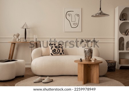 Creative composition of living room interior with mock up poster frame, white sofa, patterned pillow, wooden coffee table, stylish pouf, chrom lamp and personal silver accessories. Home decor Template