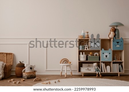 Creative composition of living room interior with wooden colorful sideboard, plush toys, beige wall with stucco, round rug, wooden block, braided basket and personal accessories. Home decor. Template.