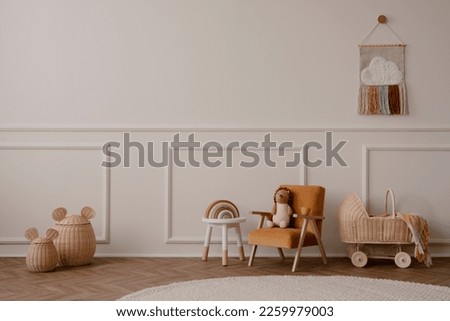 Minimalist composition of kids room interior with velvet orange armchair, braided cradle, baskets, round rug, white stool, beige wall with stucco and personal accessories. Home decor. Template.