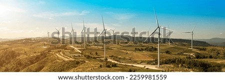 wind turbines in a field, wind turbine farm sundown, Wind Power Turbines in a rural area, Tracking shot of energy producing wind turbines in Oregon. Royalty-Free Stock Photo #2259981559