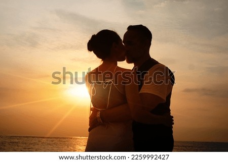 Senior business man and his wife hugging and kissing on celebration event at the yacht deck,Silhouette romance scene marriage anniversary over sunset, luxury and happiness moment Royalty-Free Stock Photo #2259992427
