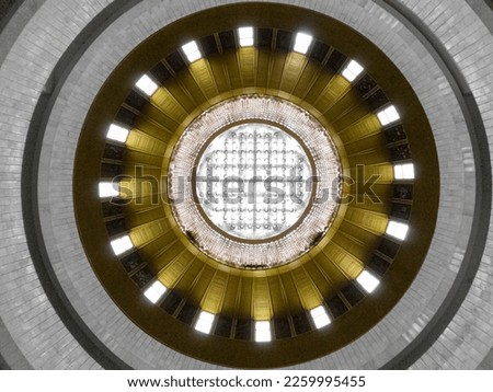 A round large celling window in a spacious round hall in a modernist interior with round balconies lined with white marble  in NC "Ukrainian House". Kyiv, Ukraine. Royalty-Free Stock Photo #2259995455