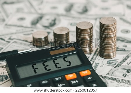 Calculator with the word FEES on the calculator placed on the dollar, concepts, fees, fees services and taxes. Royalty-Free Stock Photo #2260012057