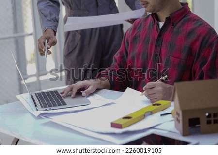 young architect or engineering builder in hard hat with tablet over group of builders at construction site, architect watching some a construction, business, building, industry, people concept