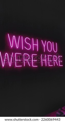 Neon sign with text wish you were here