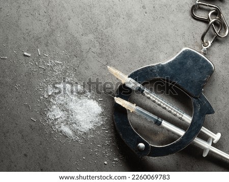Handcuffs, drug syringe and drug powder