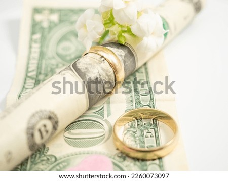 Wedding rings and dollars. The concept of marriage of convenience. Close-up.