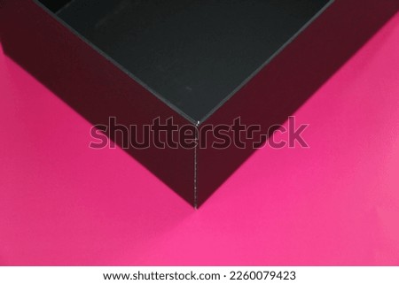 selective focus: black box on pink background