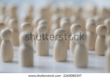 Crowd of people and society concept. Many wooden figures standing close to each other, shallow depth of field.