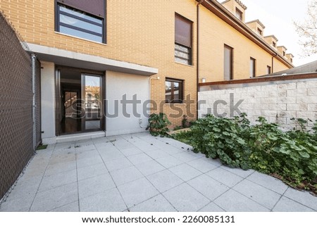Patio for private use of a single-family home with a bit of land full of plants and white brick walls