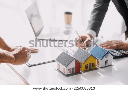 Real estate brokerage agent Deliver a sample of a model house to the customer, mortgage loan agreement Making lease and buying a house And contract home insurance concept Royalty-Free Stock Photo #2260085813
