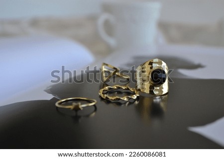 Gold-plated silver rings on an image of Marilyn Monroe and with a coffee in the background of the image