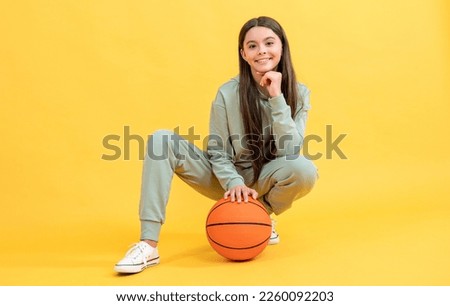 photo of positive teen basketball girl with ball. teen basketball girl isolated on yellow.