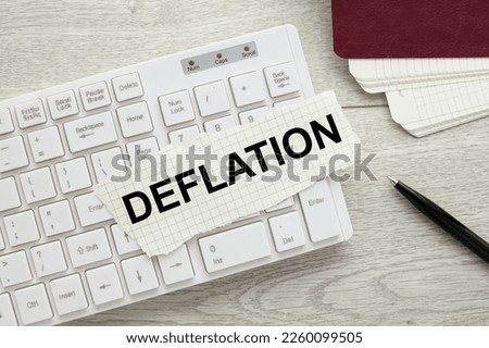 Deflation concept. torn white paper on a white keyboard. text in black Royalty-Free Stock Photo #2260099505