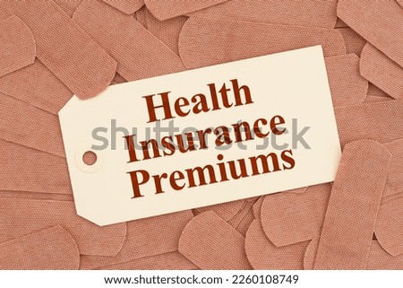 Health insurance premiums message on a gift tag with lots of fabric adhesive band aids with for your medical or injury message