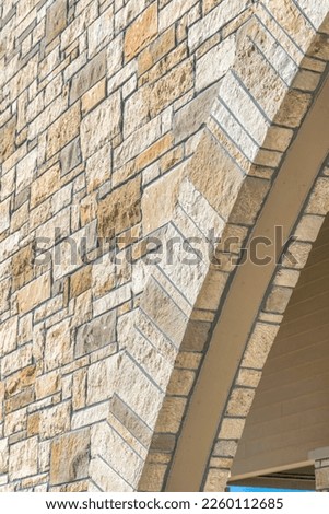 Close-up of an arch at the entrance of a building with stone veneers at Austin, Texas. Low angle view of the arch frame of the entrance of a french country home. Royalty-Free Stock Photo #2260112685